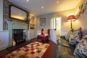 The lounge in The Snug, featuring a cosy fireplace. Unique places to stay in the UK