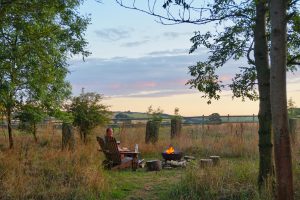 Matt sat by the fire pit while glamping in a shepherd's hut at Warmwell House in Dorset.