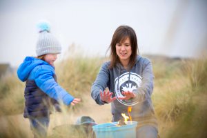 Emily and I warming our hands up over the camp fire during our photo shoot for Westbeach clothing company