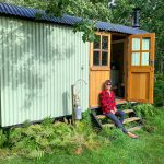 Me sat outside the shepherd's hut on our glamping trip in Dorset.
