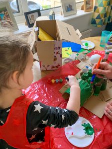 Emily painting our cardboard crocodile - things to do with kids during lockdown