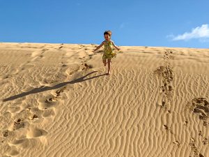 Emily running down the sand dunes, Fuerteventura