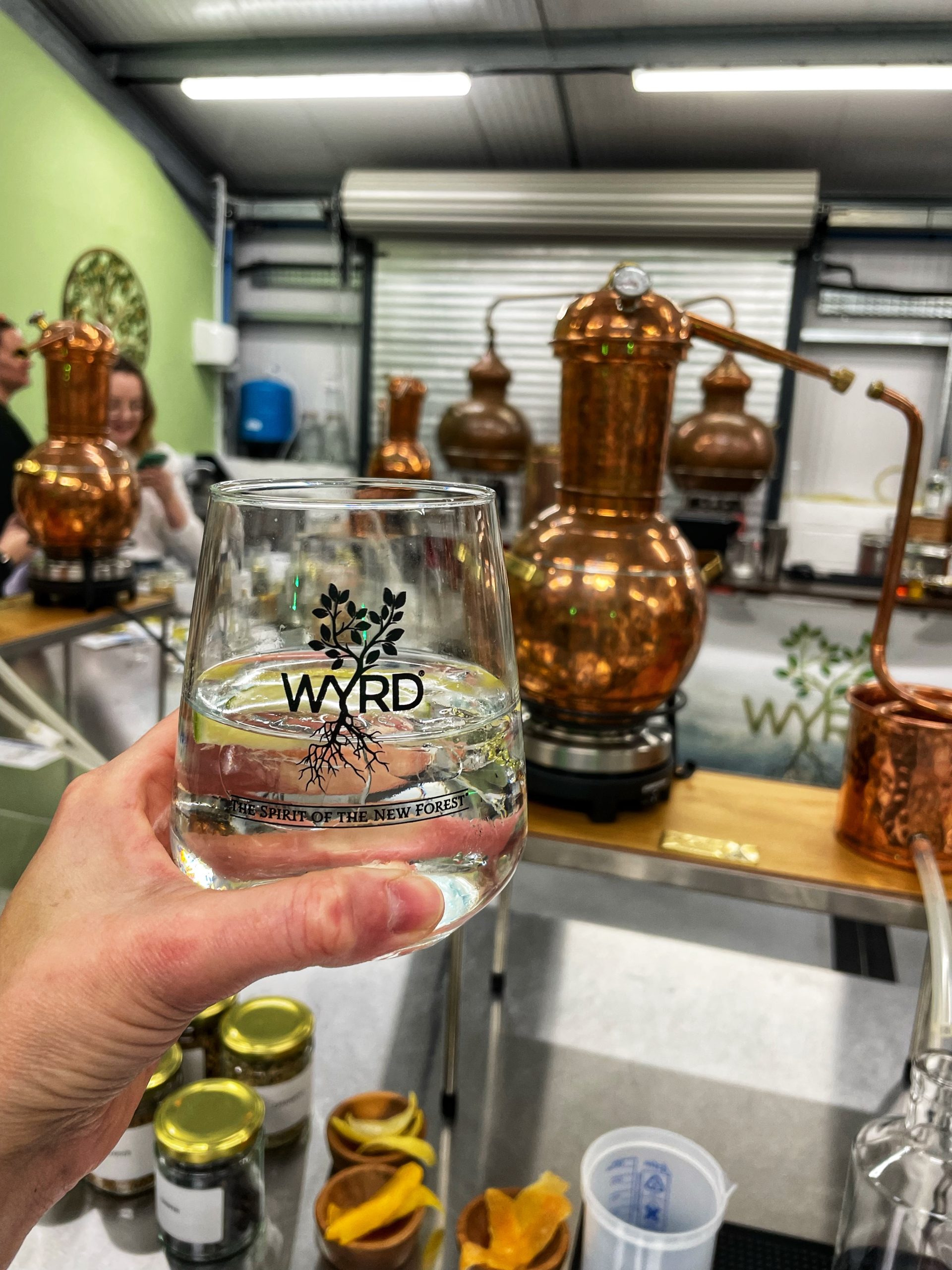 Glass of gin and tonic with copper gin still in background