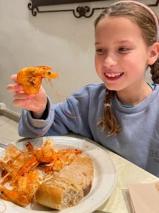 Girl holding cook prawn at Sol Lanzarote restaurant.